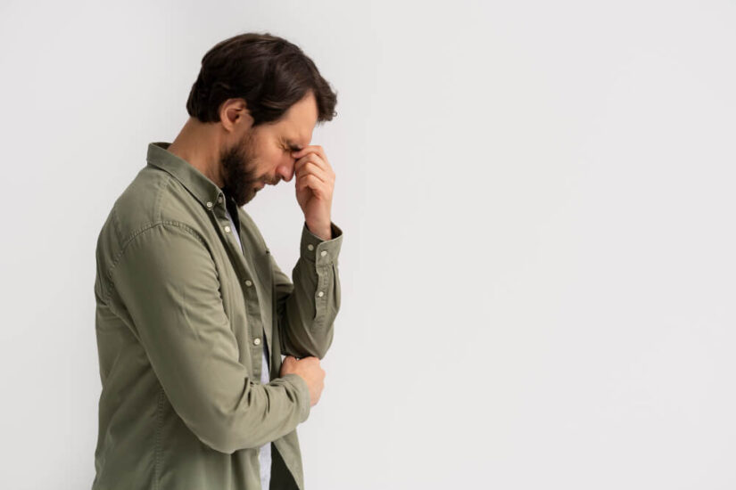 Anxious Man With His Head Down and His Hand on His Forehead